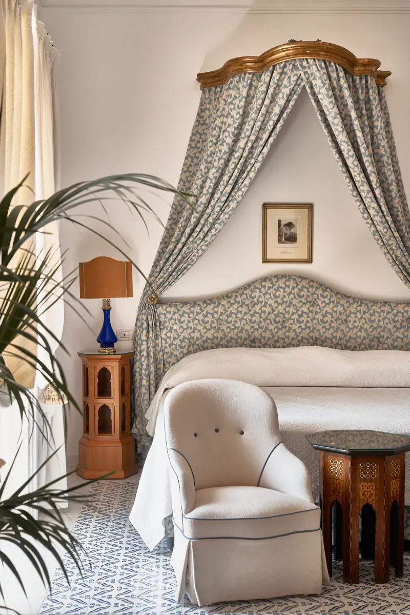 A canopied bed with blue and cream fabric